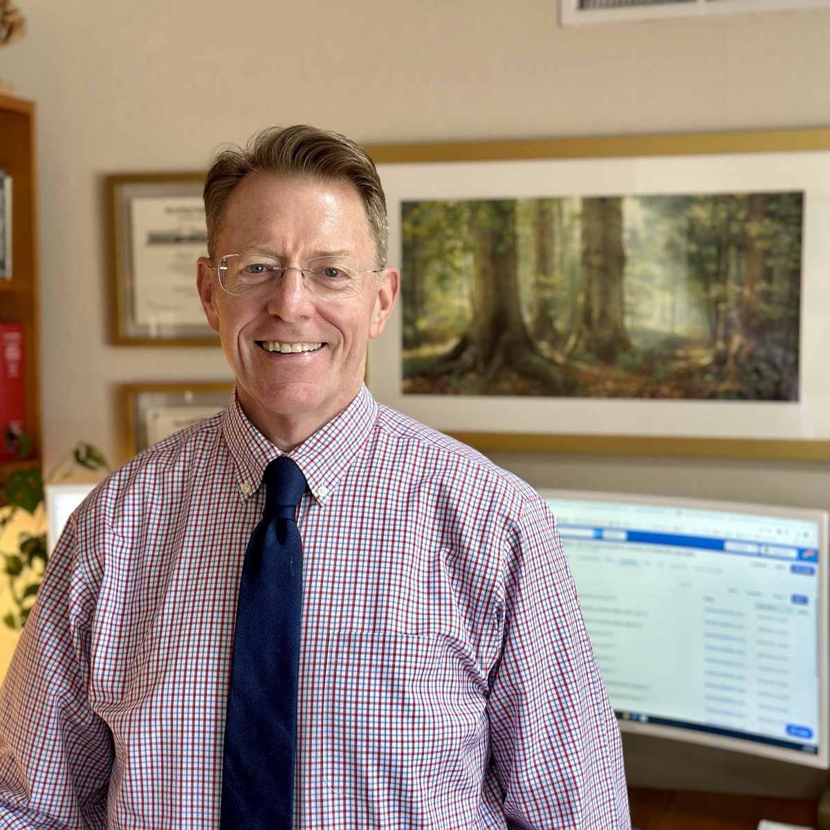 Mark A. Tucker in his office, framed diplomas on the wall behind him